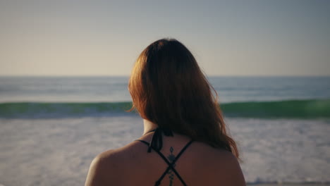 girl walking towards the sea back view slow motion