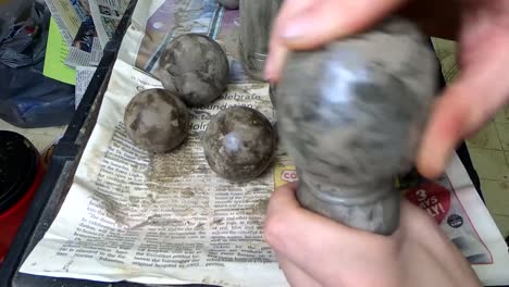 making a sphere out of clay using a glass jar