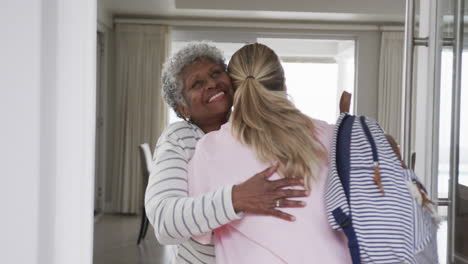 smiling caucasian nurse hugging with senior african american woman patient, slow motion