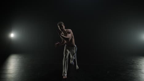 luchadores de capoeira realizando movimientos dinámicos en el escenario. artes marciales, danza y acrobacias en acción. atletas de pecho desnudo mostrando fuerza, flexibilidad y técnica bajo los reflectores