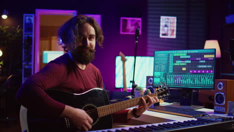 musician plays acoustic guitar and records melody to compose new song