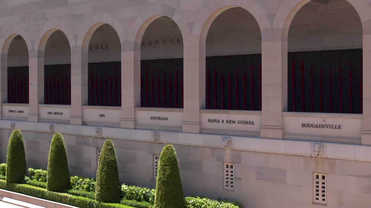 Barrido lento de cámara a través de los arcos de arenisca y la piscina reflectante en el Australian War Memorial