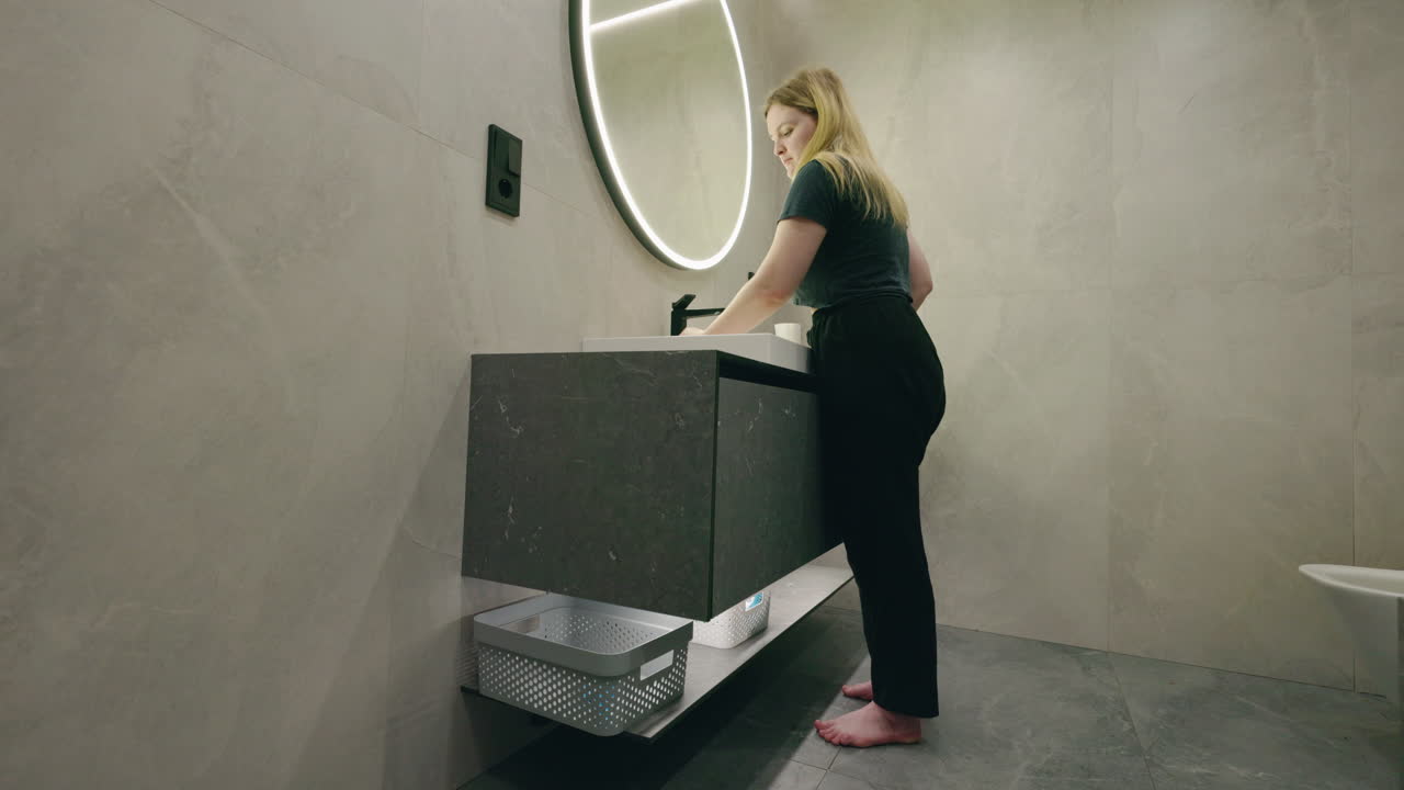 Woman Washing Hands in Modern Bathroom