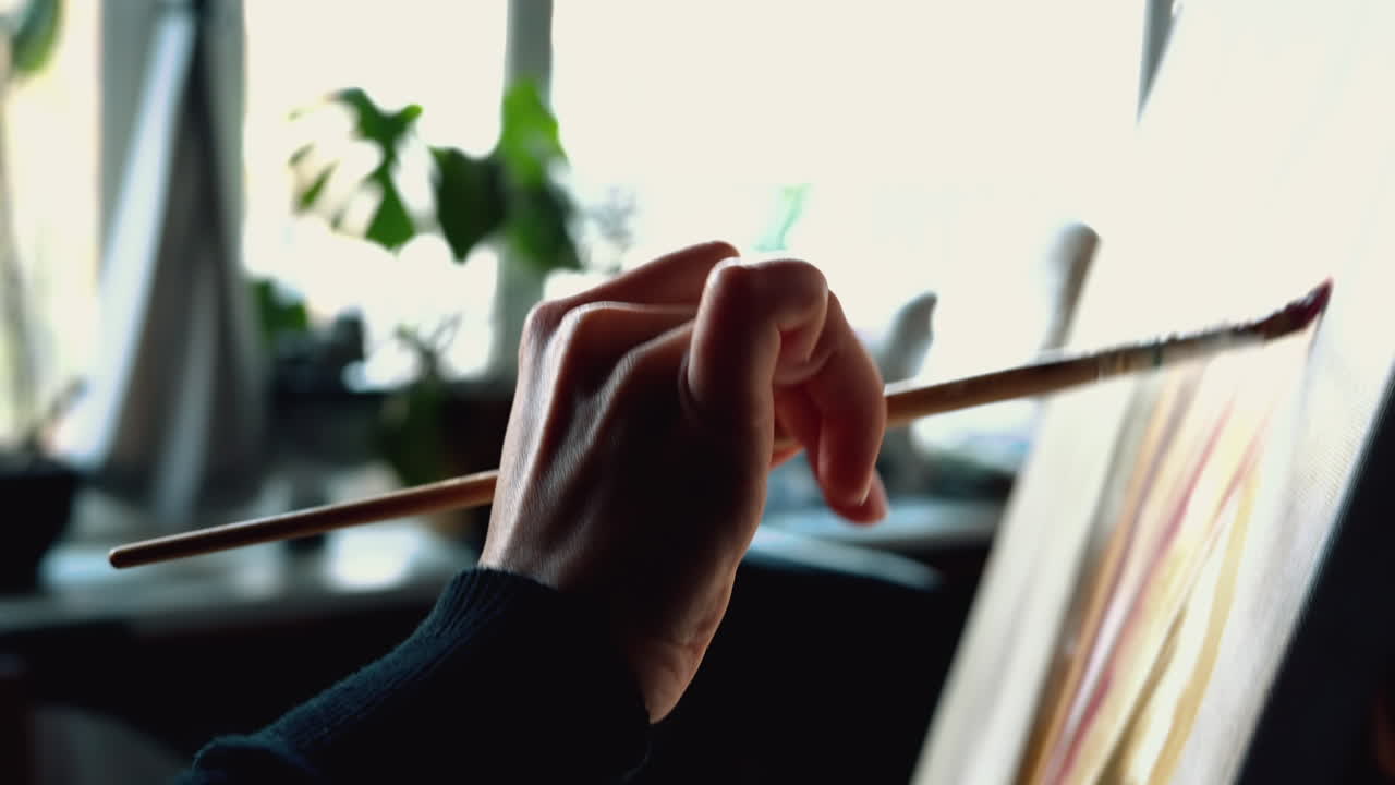 Close up of a woman painting on a canvas at an art gallery workshop