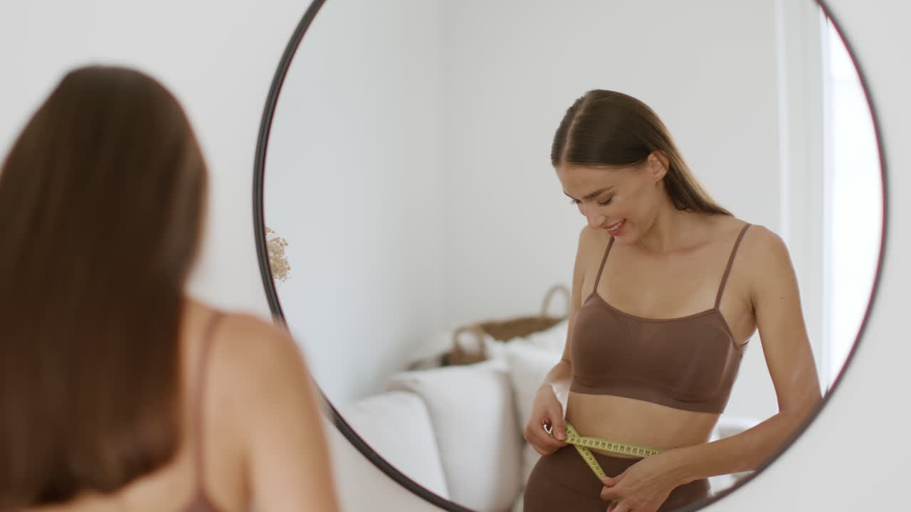 Woman Measuring Waist in Mirror