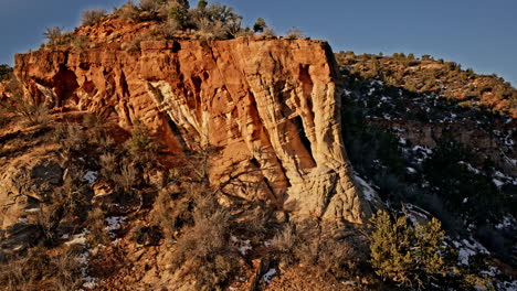 sunrise drone shot soaring over a hidden sandstone arch nestled in the desert near kanab, utah.