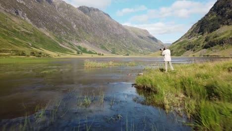 photographer in green valley and lake
