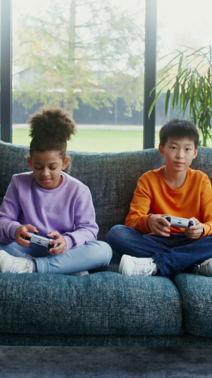 Two kids playing video games on a couch