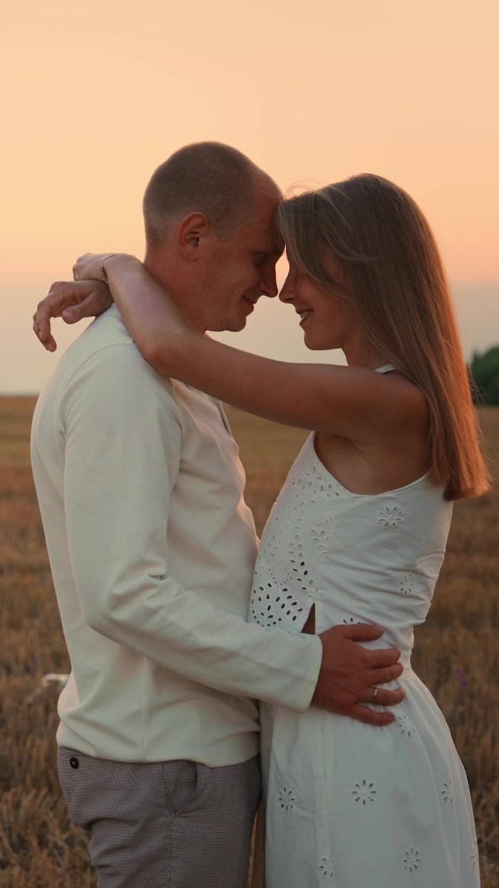 Casal Romântico Abraçando-se em um Campo de Trigo Dourado ao Pôr do Sol