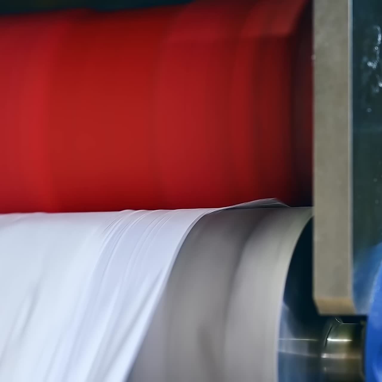 Quick movement of diaper cloth from the shafts. Conveyor line releasing the material at the diaper factory. Close up