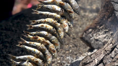 brocheta de pescado de sardinas al fuego a la parrilla con leña ardiendo