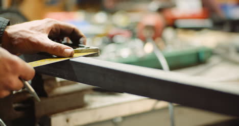 hombre que trabaja en la industria metalúrgica cortando y midiendo piezas metálicas en el taller 7