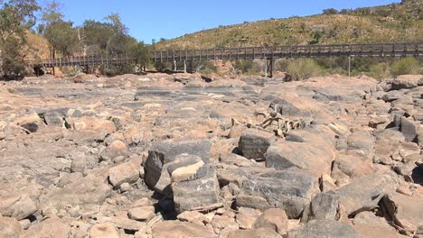 Reveal-shot-of-a-riverbed-full-of-rocks-and-no-water-after-a-dry-summer