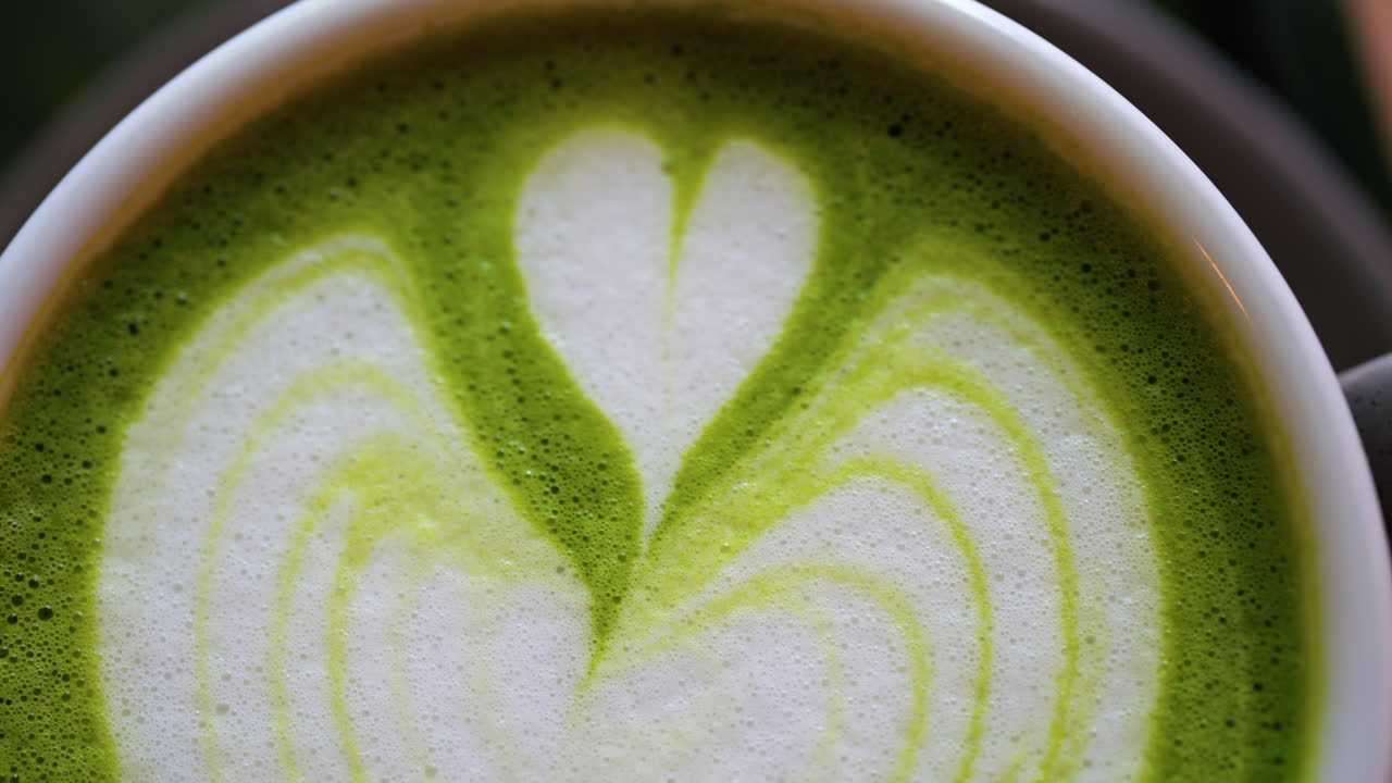 Close up of a matcha latte on a little green tray at a cafe