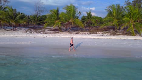 tourist walking on the white sand beach of koh rong island in cambodia, asia fantastic aerial view flight dolly right drone