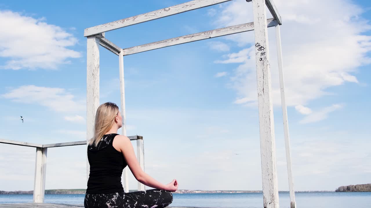 Woman Meditating on a Pier by the Lake
