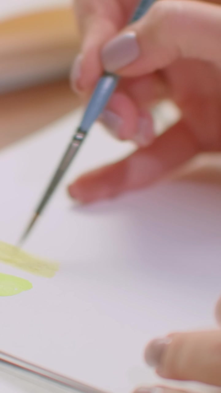 Artist Painting Yellow Watercolor Strokes on Paper