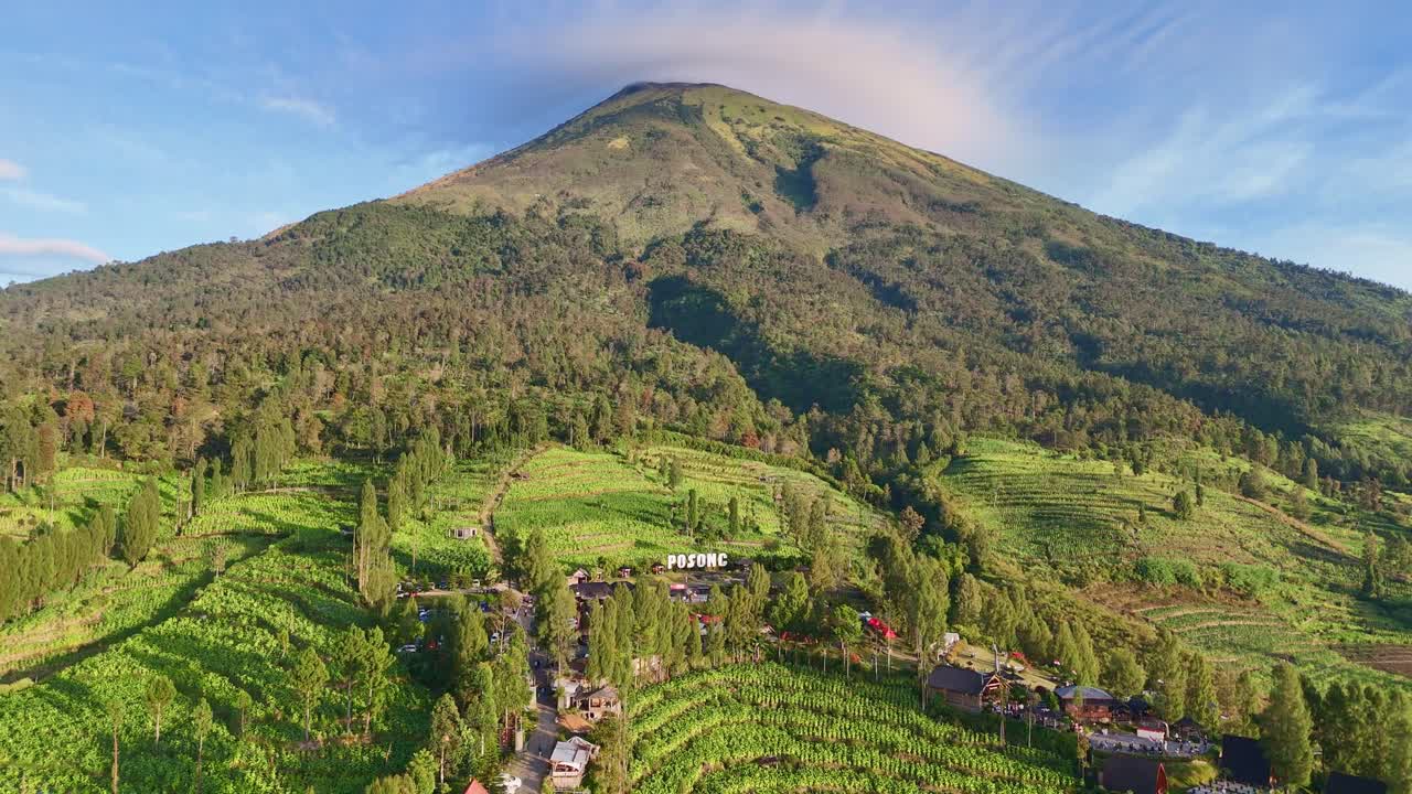 Dronie shot from Posong Natural Park Tourist Destination in the middle of green plantation on the slope of Sindoro Mountain. 4K drone view of Indonesia nature landscape.