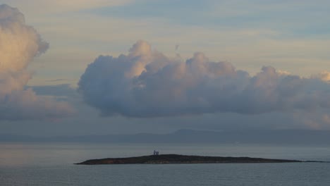 Clouds-rolling-over-a-small-island-at-sunset---time-lapse