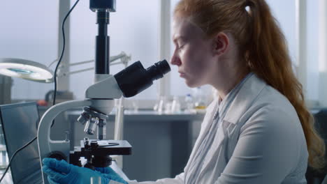 scientist looking through a microscope in a laboratory