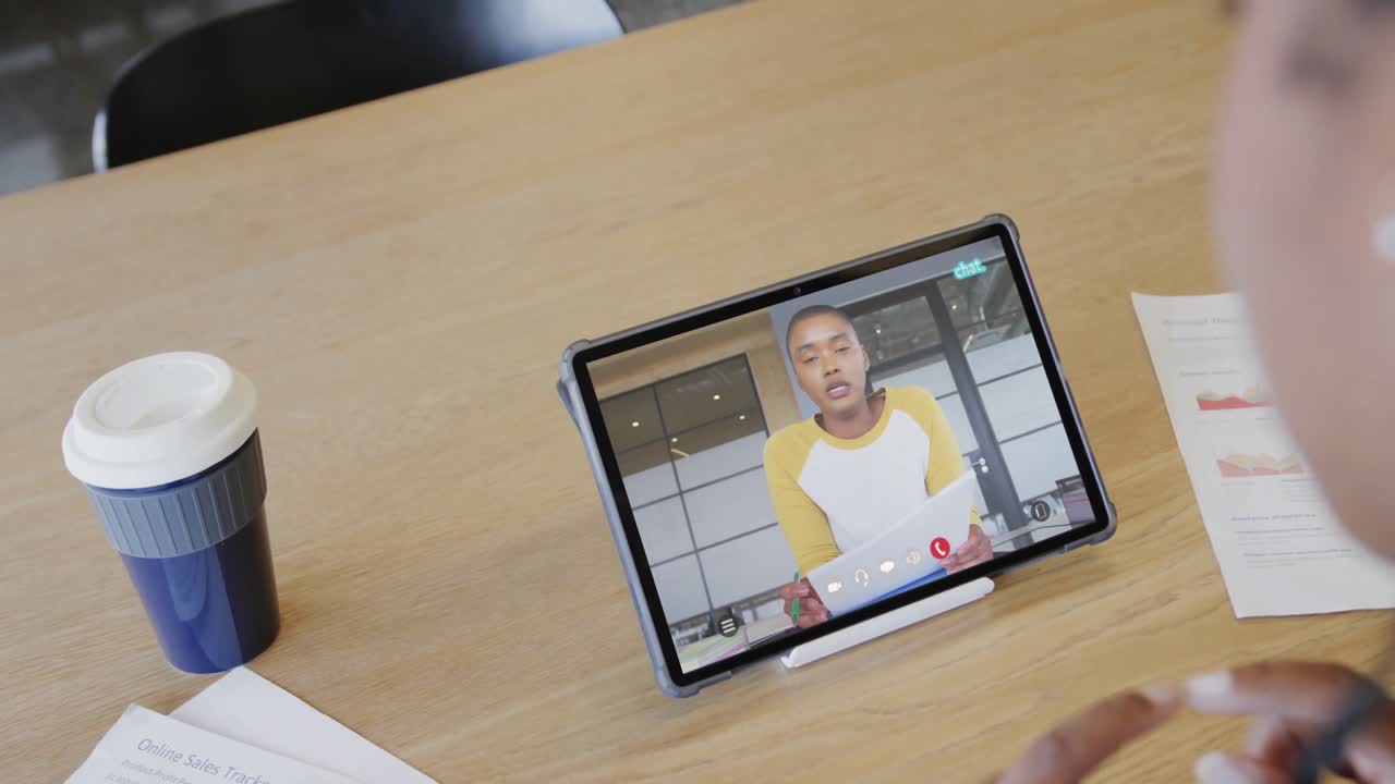 mujer de negocios caucásica en una videollamada con un colega afroamericano en la pantalla