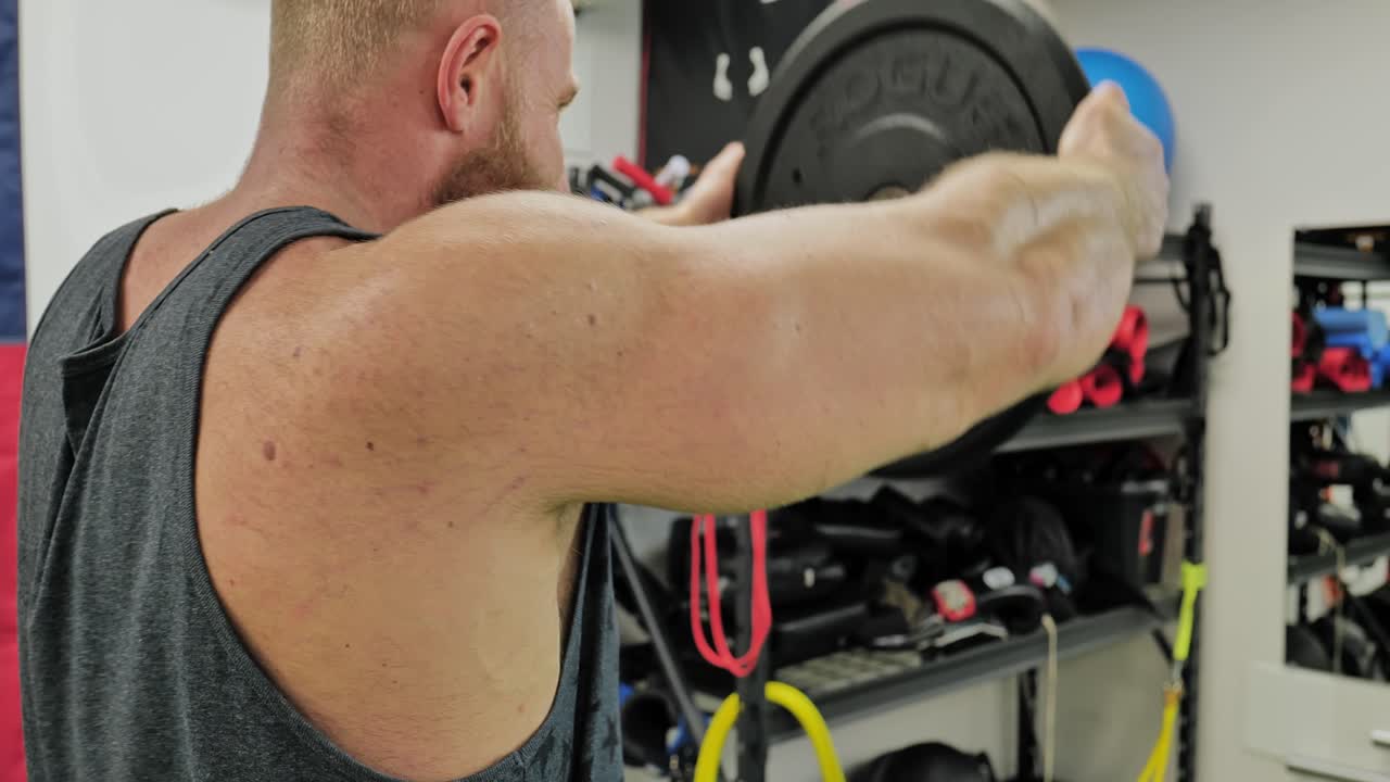 Active bodybuilder young man lifting heavy weights