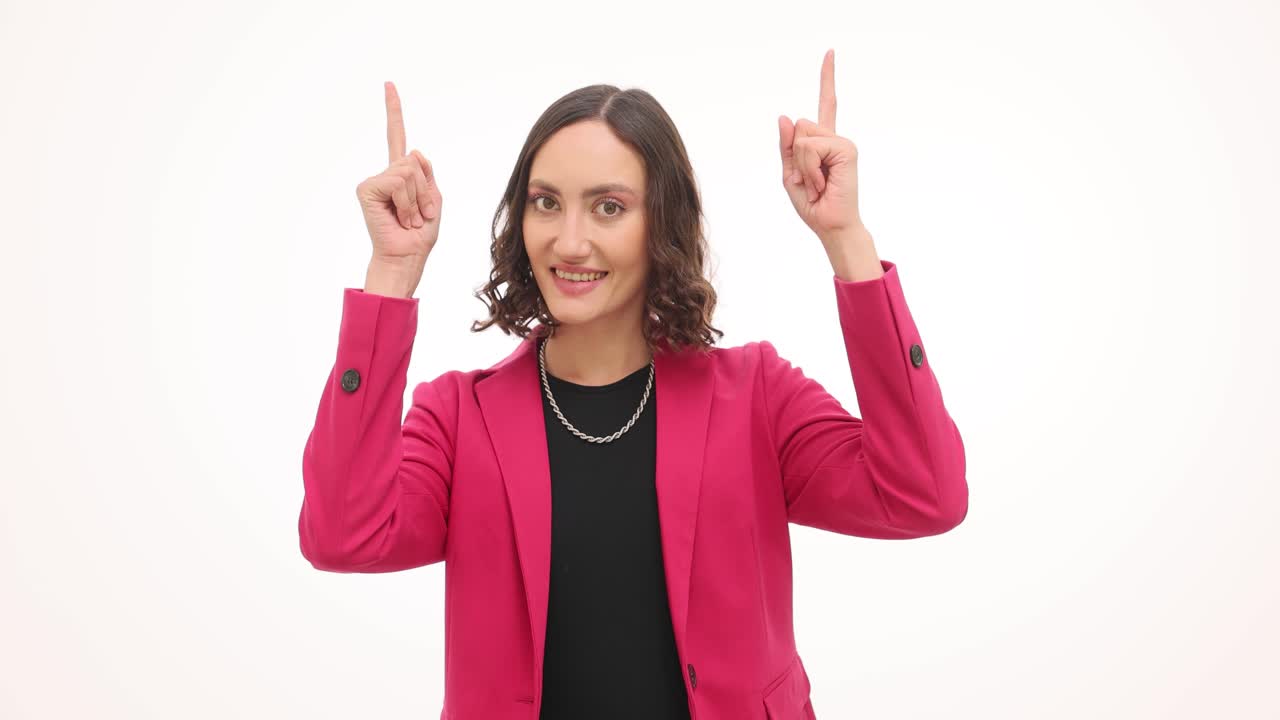 Woman in pink blazer pointing upwards