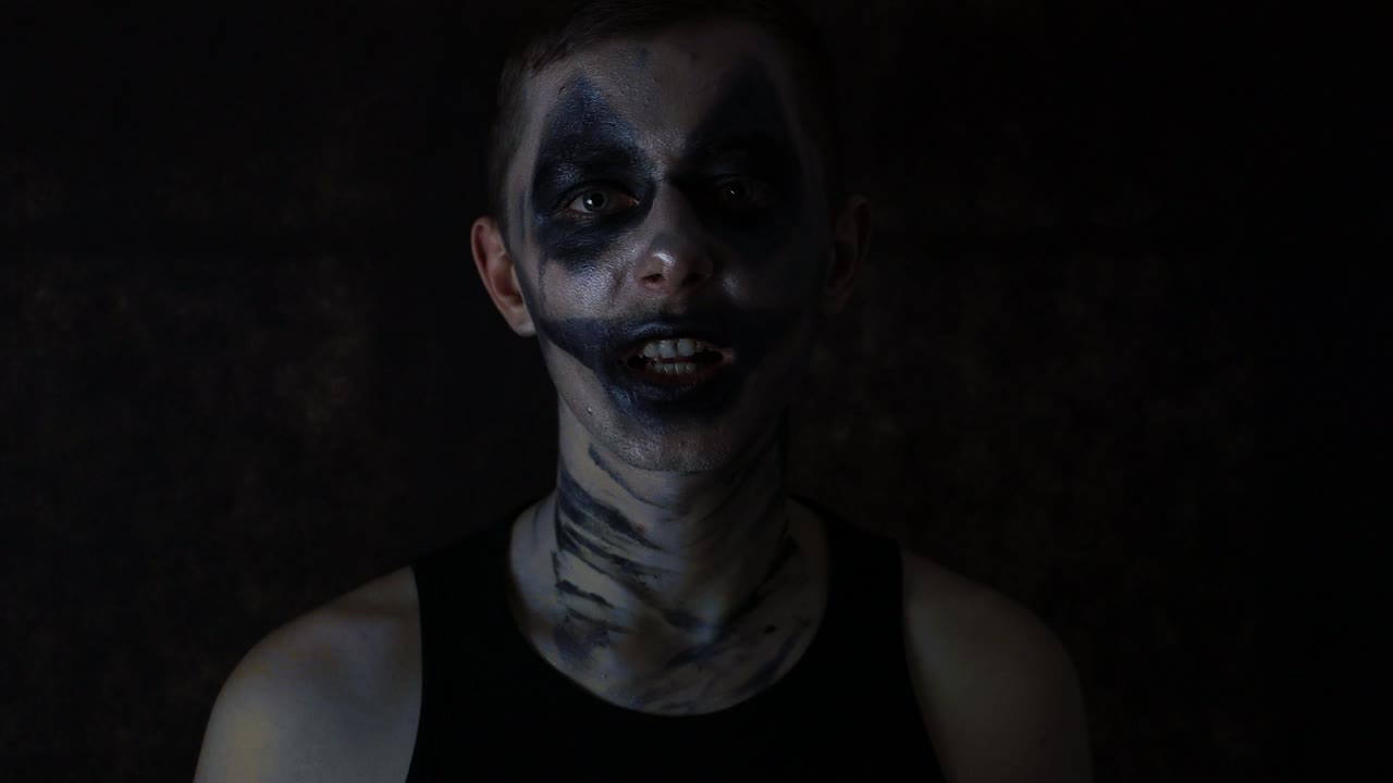 primer plano de un joven con oscuro triste halloween payaso maquillaje hablando emocionalmente a la cámara