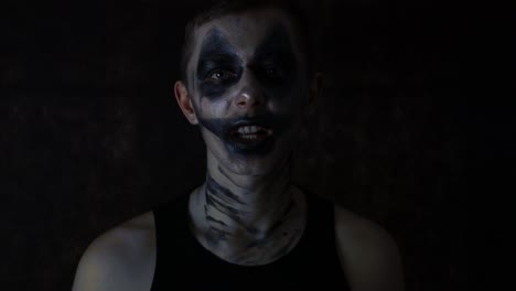 close up of a young man with dark sad halloween clown makeup talking emotionally to the camera