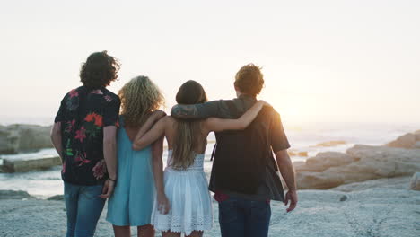 espalda, grupo de amigos y playa con puesta de sol