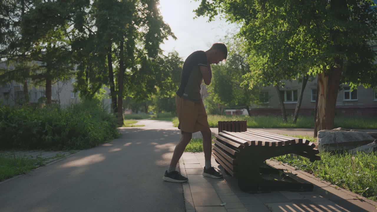 Person Attentively Inspecting Wooden Bench Gap, Male Figure Focused On Analyzing Space Between Bench Slats, Man With Careful Hands Examining Wooden Slat Gap In Peaceful Suburban Park Setting
