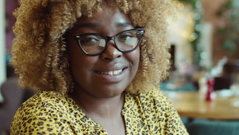 portrait of smiling african american woman in cafe