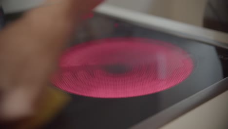 female hand cleaning a burner on kitchen electric stove