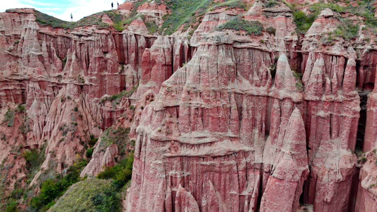 Dramatic red cliffs of Râpa Roșie under a cloudy sky, showing erosion