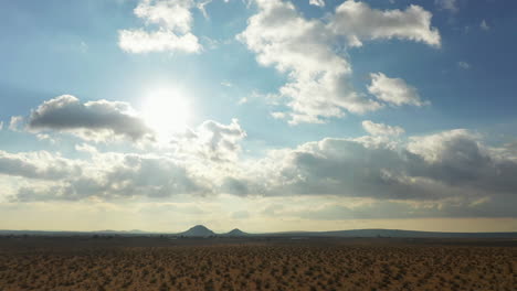 as the bright sun heats the mojave desert, the gather clouds provide some relief - sliding aerial view