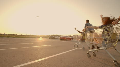 A-group-of-young-people-fun-ride-on-carts-near-the-store-supermarket