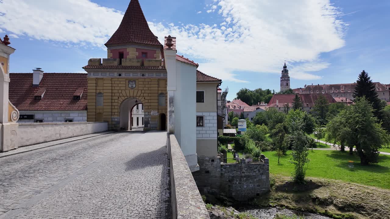 View from Budweiser Gate in Český Krumlov overlooking lush greenery and historic buildings