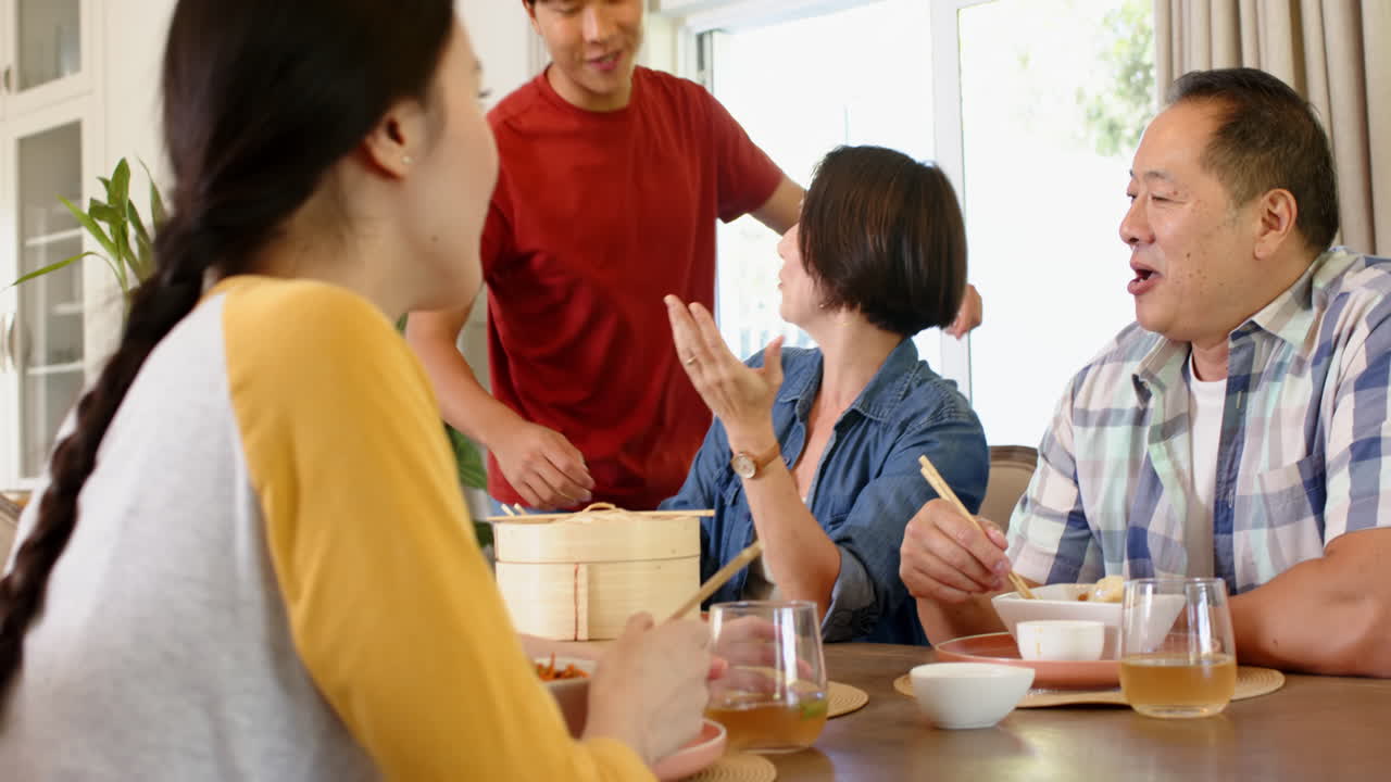 Enjoying family time, group of people sharing meal and laughing together