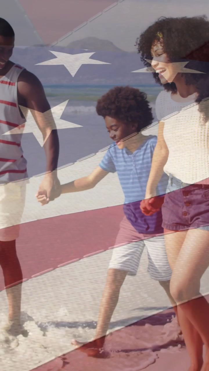 海辺のビーチを息子と娘と歩く幸せなアフリカ系アメリカ人の両親。