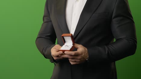 hombre de traje negro muestra anillo de compromiso