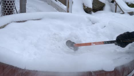 close view of a person hammering snow to break the ice