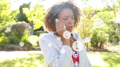 animation of network of connections with icons over biracial woman talking on smartphone