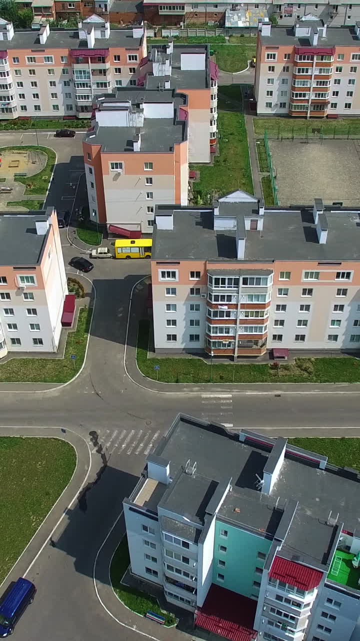 New residental building appartments in modern complex near the green fields in summer. Beautiful flying over the city in a new district. Aerial view Vertical video