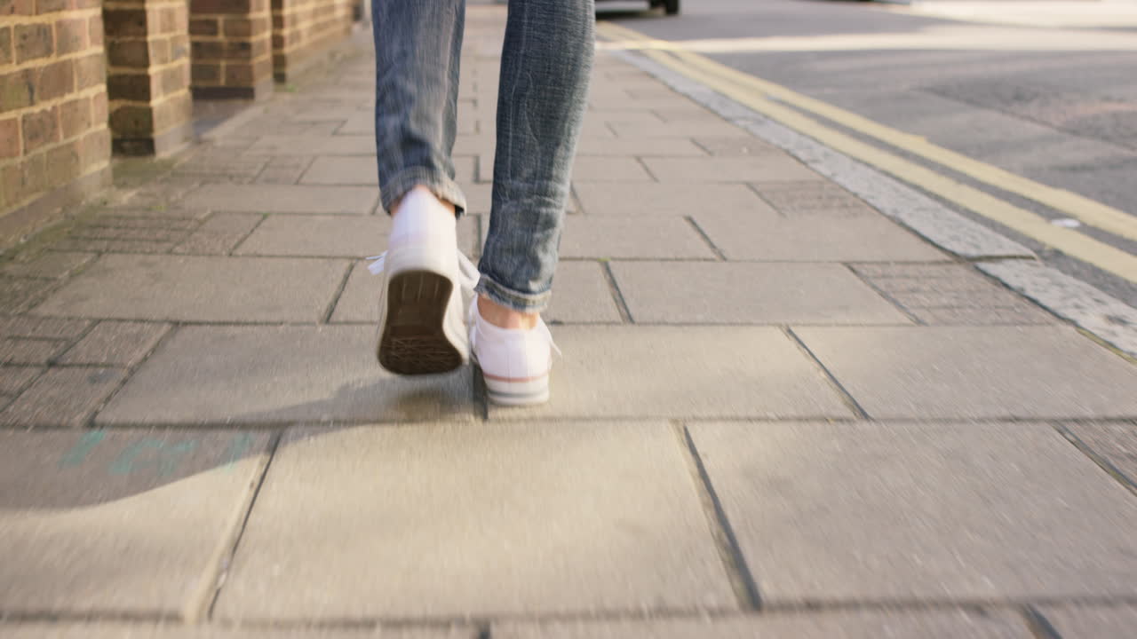 Detail of woman's feet walking through city