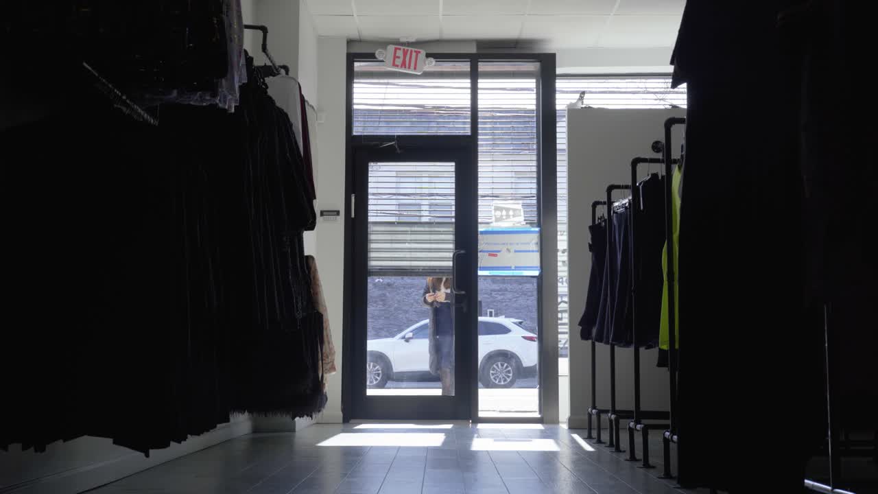 Woman unlocks and enters retail store and turns on the light