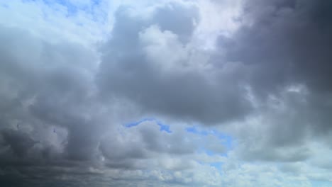 nubes de tormenta onduladas corriendo más allá de la cámara con manchas de cielo azul, 60x lapso de tiempo
