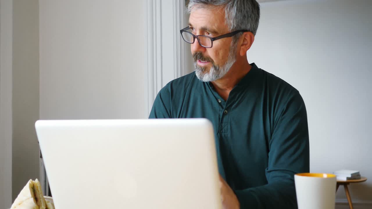 hombre usando portátil en la sala de estar 4k