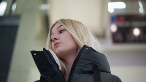 young girl standing on moving escalator in modern mall, looking around, blurry background features urban environment, creating a lively yet relaxed atmosphere in the mall setting