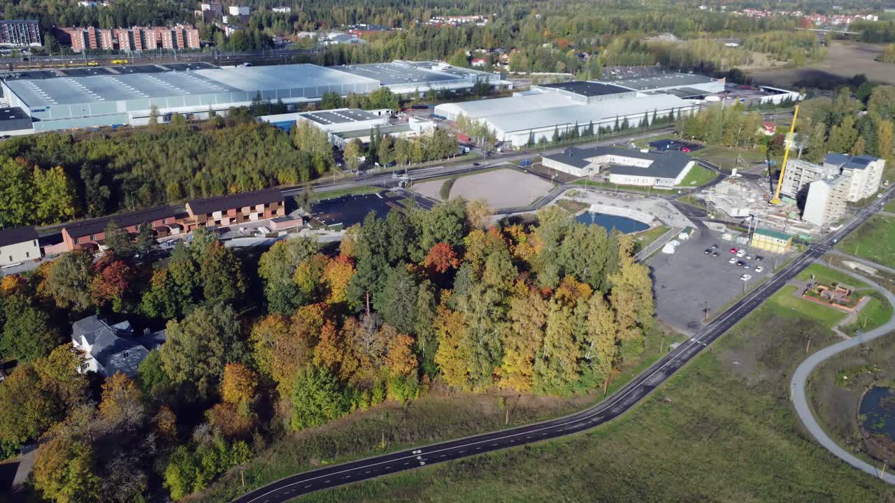 Flyover suburban warehouses with trees in bright autumn colors