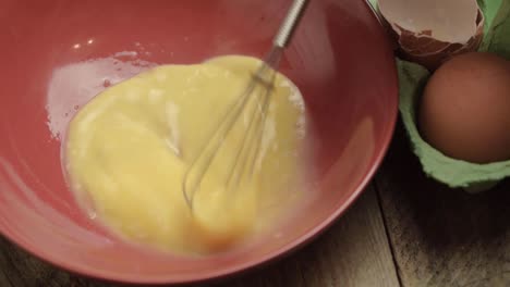 whisking raw egg in a bowl close up